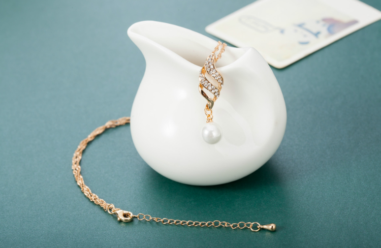 Elegant pearl jewelry gift set featuring a pearl pendant and sparkling chain on a decorative display