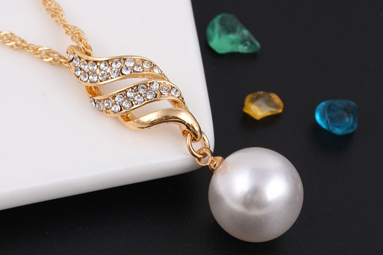 Elegant pearl jewelry gift set featuring a gold pendant with sparkling stones and a large pearl drop