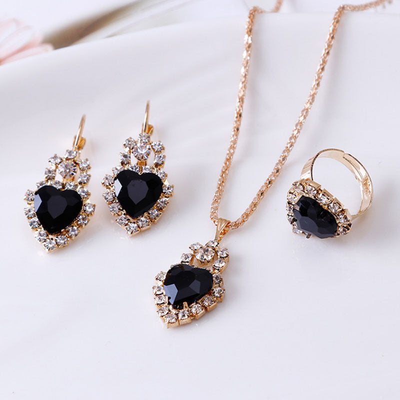 Stylish 3Sixty5 rhinestone jewelry set featuring heart-shaped earrings, necklace, and ring in gold and black
