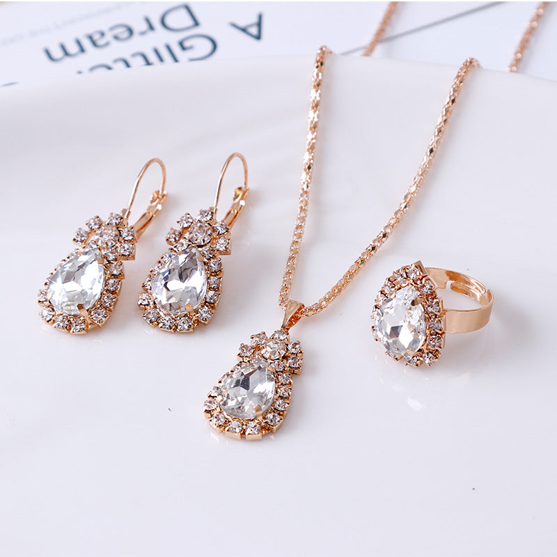 Elegant rhinestone jewelry set featuring necklace, earrings, and ring in rose gold tone