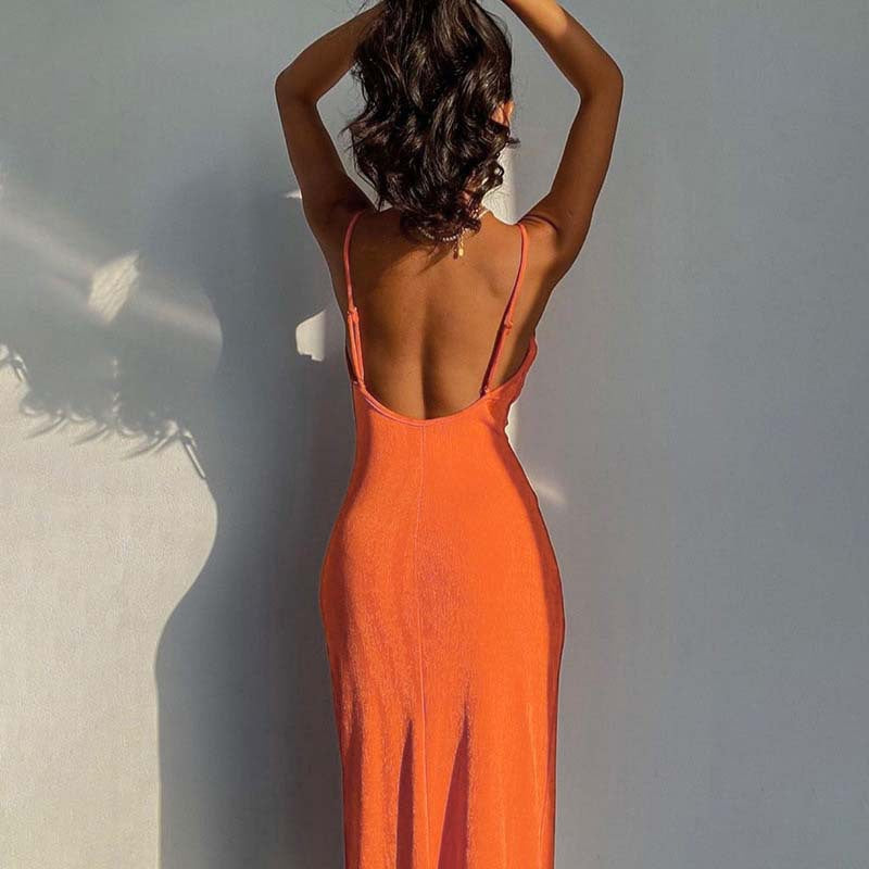 Back view of a woman wearing a stylish smooth knit dress in orange with a low back design