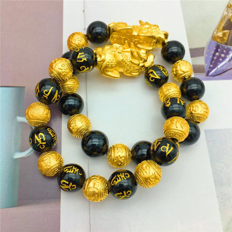 Trendy gold bracelet featuring black beads and distinctive gold detailing for a stylish look